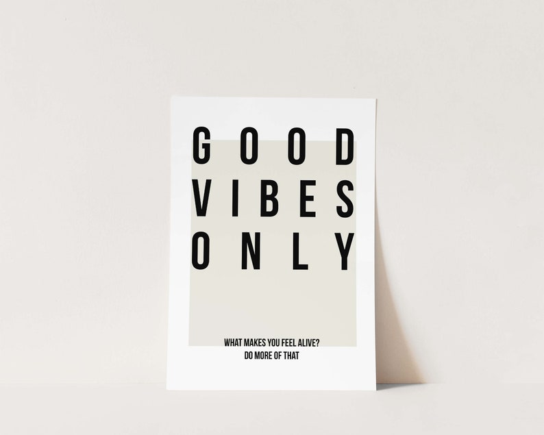 May include: A white poster with black text that reads "GOOD VIBES ONLY" and the text "WHAT MAKES YOU FEEL ALIVE? DO MORE OF THAT".