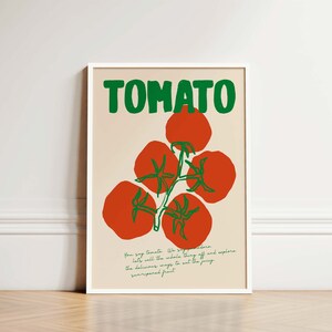 May include: A white framed poster with the word "TOMATO" in green letters. The poster features a red tomato vine with green leaves and five red tomatoes.