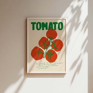 May include: A white framed poster with the word "TOMATO" in green letters and a red tomato illustration. The text below the illustration reads "How big Tomato. We say, "go ahead, let's eat the whole thing" off and explore the delicious ways to eat this juicy sun-ripened fruit."