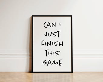 May include: Black and white framed print with the text "CAN I JUST FINISH THIS GAME" written in a handwritten style.