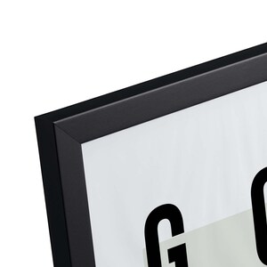 May include: Black picture frame with a white mat and the word "GOOD" printed in black.