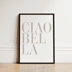 May include: A black framed print with the text "CIAO BEL LA" in a light gray color on a white background.