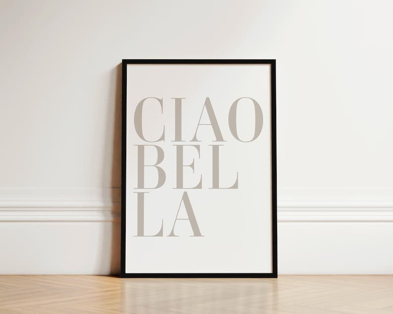May include: A black framed print with the text "CIAO BEL LA" in a light gray color on a white background.