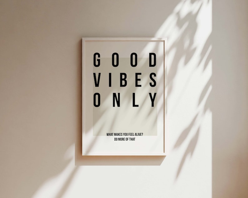 May include: A white framed print with the text "GOOD VIBES ONLY" in black letters. The print also includes the text "WHAT MAKES YOU FEEL ALIVE? DO MORE OF THAT."