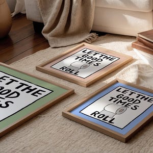 May include: Three framed prints with a green, pink, and blue background. Each print features a black and white illustration of a toilet paper roll with the text "Let the good times roll".