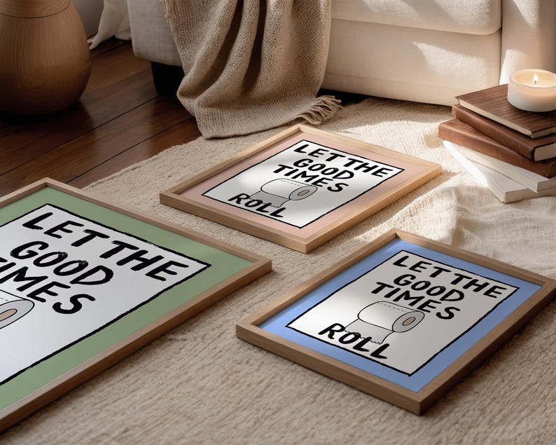 May include: Three framed prints with a green, pink, and blue background. Each print features a black and white illustration of a toilet paper roll with the text "Let the good times roll".