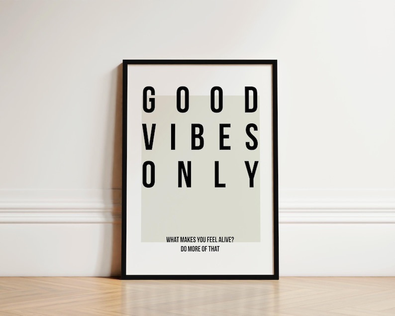 May include: Black framed print with a white background and the text "GOOD VIBES ONLY" in black. The text is in a grid pattern. Below the text is the phrase "WHAT MAKES YOU FEEL ALIVE? DO MORE OF THAT."