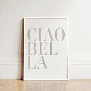 May include: A white framed print with the text "CIAO BEL LA" in a light gray color.
