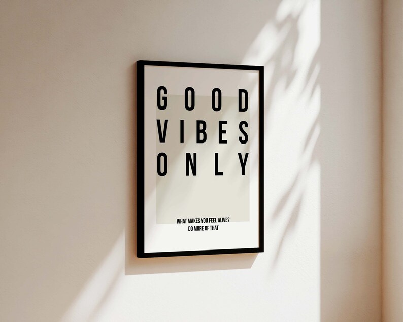 May include: Black framed print with white background and the text "GOOD VIBES ONLY" in black. The text is arranged in a grid pattern. Below the text is the phrase "WHAT MAKES YOU FEEL ALIVE? DO MORE OF THAT."