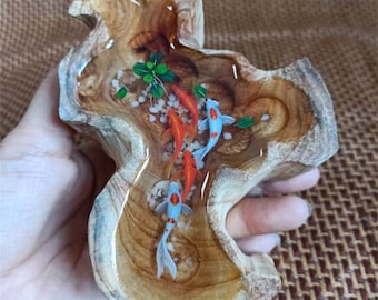 May include: A wooden bowl filled with clear resin and painted fish. The fish are orange and blue with white accents. The bowl is a natural wood color with a rough texture.