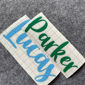 May include: Two vinyl decals, one with the name "Lucas" in light blue and the other with the name "Parker" in dark green.