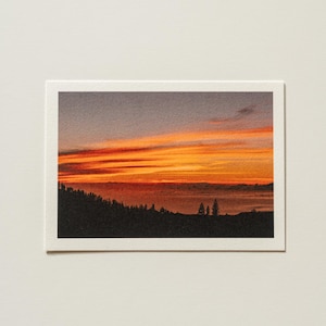 Postal con impresión artística de la hora dorada y puesta de sol en el mar