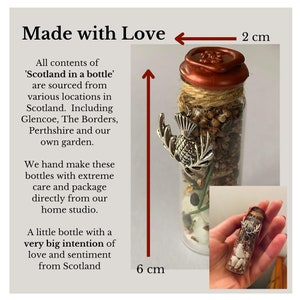 Puede incluir: Una peque&ntilde;a botella de vidrio llena de elementos naturales, incluyendo un amuleto de cardo plateado. La botella mide 6 cm de alto y 2 cm de ancho. La botella est&aacute; etiquetada como 'Scotland in a bottle' y est&aacute; hecha con amor y cuidado.