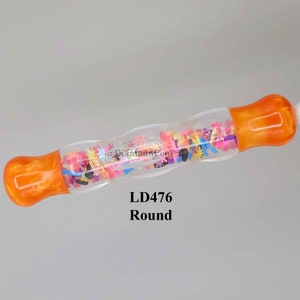 May include: A clear, round diamond painting pen with orange resin ends. The barrel is filled with colorful confetti shapes. The text "LD476 Round" is printed below the pen.