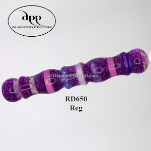 Puede incluir: Un objeto decorativo morado y rosa con acabado brillante. Tiene forma cilíndrica con extremos redondeados y bandas rosas y moradas. El texto "RD650 Reg" está impreso en el objeto.