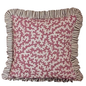 May include: Square decorative pillow with a white background and a repeating pattern of burgundy coral-like shapes. The pillow has a ruffled border with a striped pattern in shades of gray and white.
