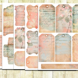May include: A set of 10 vintage-style printable tags with a pink and blue color scheme. The tags feature handwritten text, floral designs, and a distressed look. The text on the tags includes "Moderne Maison", "TELAUBE BINE", "Edouard", "SARLAT", and "GESU".