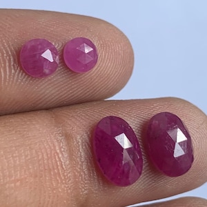 Puede incluir: Cuatro piedras preciosas de rubí facetadas, dos redondas y dos ovaladas, en varios tonos de rosa.