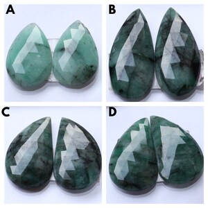 Könnte beinhalten: Vier Paare smaragdgrüner Edelstein-Cabochons, jedes Paar nebeneinander angeordnet. Die Cabochons sind birnenförmig und facettiert geschliffen. Die Cabochons sind mit A, B, C und D gekennzeichnet.