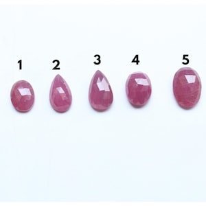 Pode incluir: Cinco pedras preciosas de rubi rosa de tamanhos diferentes, etiquetadas de 1 a 5. As pedras preciosas são facetadas e têm a forma de uma lágrima.