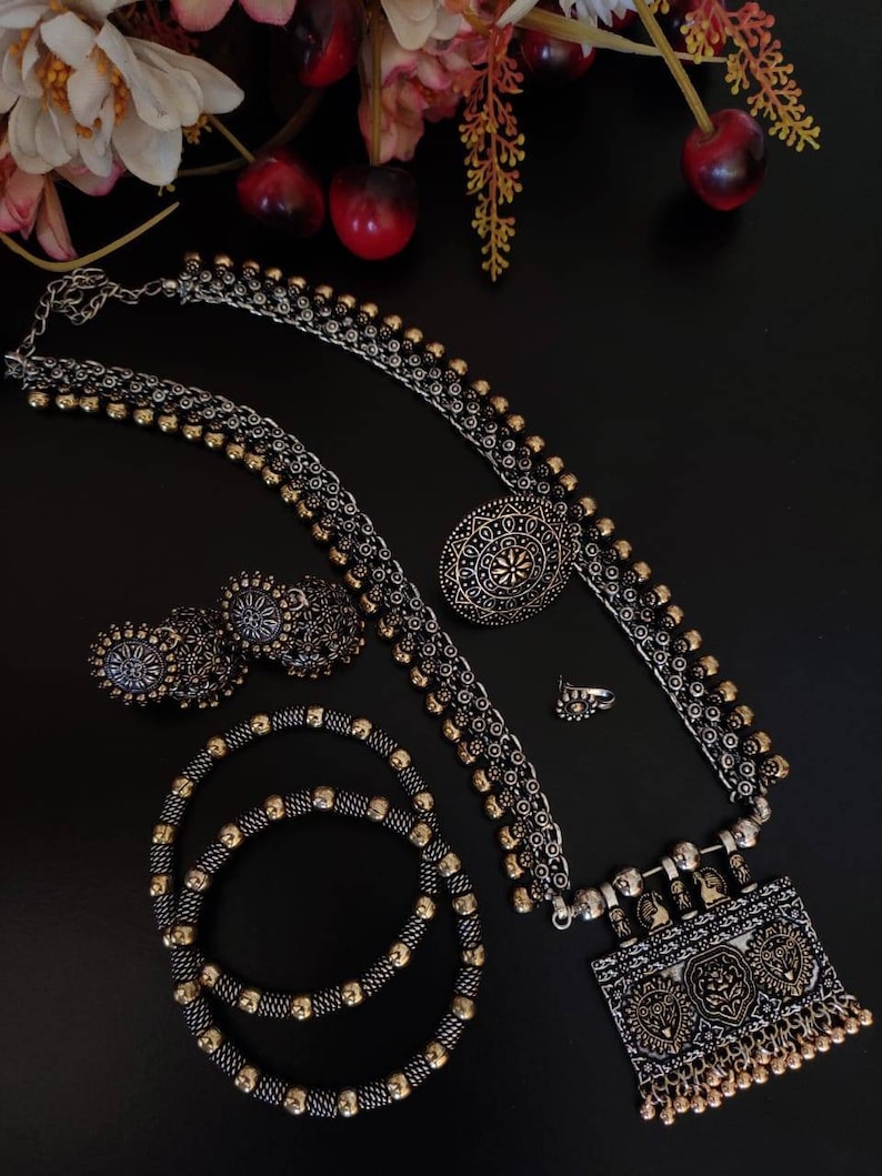 Oxidized silver tribal jewelry set with necklace earrings bangles on black background