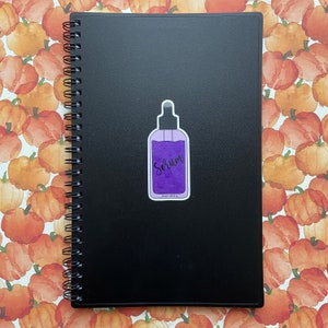 Sticker for this listing on a black spiral notebook cover