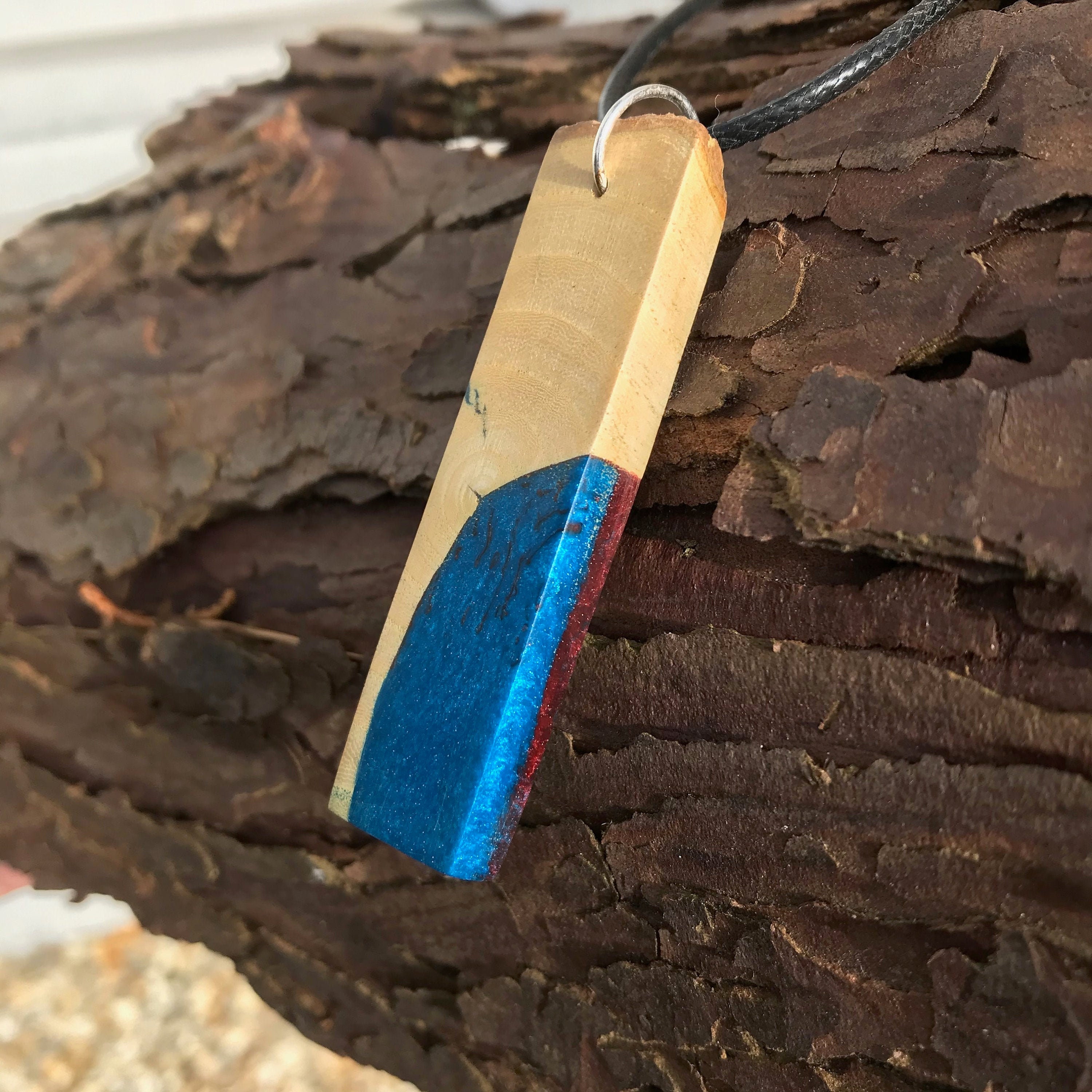 Kintsugi inspired wood slice pendant, corner infused with blue and red resin.