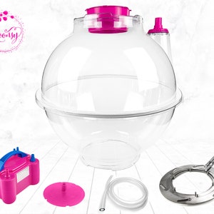 May include: A clear plastic bubble blower with a pink lid and base, a pink electric air pump, a clear plastic tube, a pink base, and a silver metal ring.