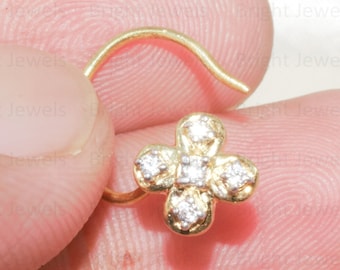 May include: A gold nose ring with a small flower design featuring clear sparkling stones.