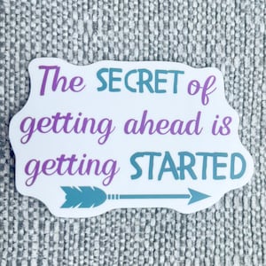 May include: A white sticker with the text "The SECRET of getting ahead is getting STARTED" in purple and teal. A teal arrow points to the right. The sticker has a decorative border.
