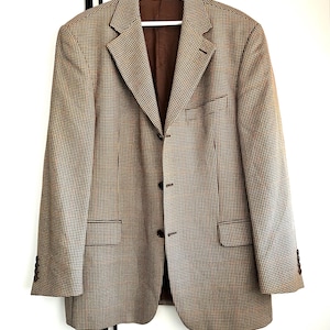 May include: A brown and beige patterned blazer with a single button closure. The blazer has a classic fit and a notched lapel.