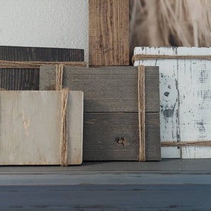 May include: Four wooden signs with a rustic look, each with a different color and texture. The signs are tied with twine and are perfect for displaying messages or photos.
