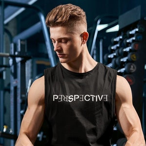 May include: A man wearing a black tank top with the word "Perspective" printed on it, sits with his legs crossed in a gym setting. He is wearing black pants and black gloves.