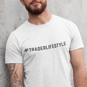 May include: A white t-shirt with the text "#TRADERLIFESTYLE" printed in black on the front.
