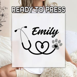 May include: White square with a black and gray stethoscope design, a heart, and a paw print. The name "Emily" is written in a stylish font. The text "READY TO PRESS" is at the top.