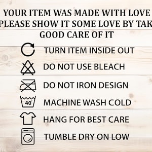 May include: Image of care instructions on a white wooden background. Text advises turning items inside out, not using bleach, and not ironing designs. Includes washing and drying symbols. The text reads: "YOUR ITEM WAS MADE WITH LOVE..."
