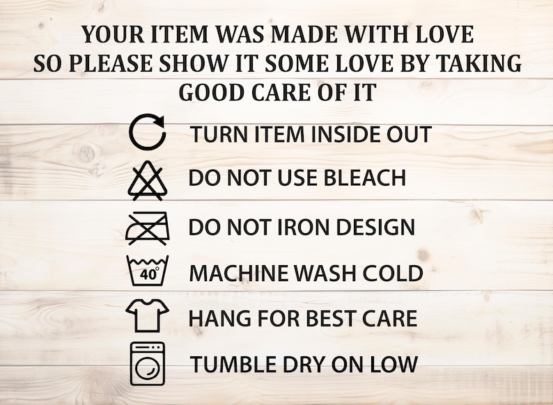 May include: Image of care instructions on a white wooden background. Text advises turning items inside out, not using bleach, and not ironing designs. Includes washing and drying symbols. The text reads: "YOUR ITEM WAS MADE WITH LOVE..."