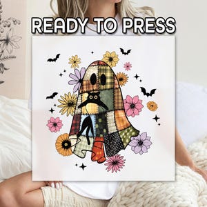 May include: A white square with a patchwork ghost design, surrounded by flowers, bats, and stars. The ghost has a black cat inside. The words "READY TO PRESS" are at the top. The design is in shades of orange, green, brown, pink, and yellow.