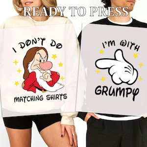 May include: Two matching shirts with cartoon graphics. One shirt features Grumpy from Snow White with the text "I DON'T DO MATCHING SHIRTS". The other shirt has a Mickey Mouse hand with the text "I'M WITH GRUMPY".