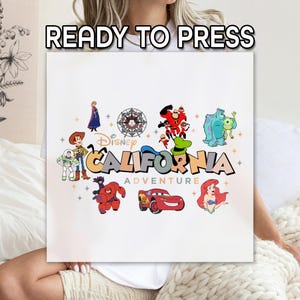May include: A white square featuring the text "READY TO PRESS" at the top. Below, the words "Disney California Adventure" are displayed with various Disney character illustrations, including Woody, Buzz Lightyear, and Ariel.