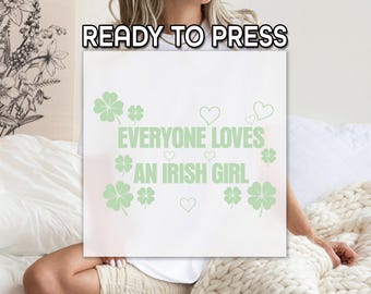 May include: White t-shirt with green shamrock designs and the text "Everyone loves an Irish girl".