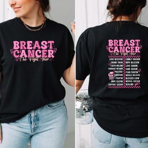 Pu&ograve; includere: T-shirt nero con testo rosa "BREAST CANCER The Fight Tour". La parte anteriore della maglietta presenta il testo in un carattere rosa a bolle con accenti di farfalla. La parte posteriore della maglietta ha un elenco di parole ispiratrici.