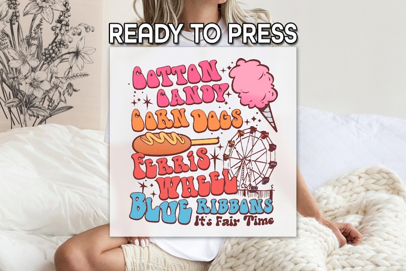 May include: A white square canvas with the words "READY TO PRESS" at the top. The canvas features a retro design with the words "Cotton Candy, Corn Dogs, Ferris Wheel, Blue Ribbons" and a pink cotton candy, corn dog, and Ferris wheel illustration.