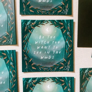 May include: A set of three square teal green and gold framed prints with the text "Be the witch you want to see in the woods" on each print. The prints have a moon and stars in the background.