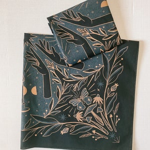 May include: Two dark green fabric bandanas with a gold print of hands reaching up, leaves, a butterfly, mushrooms, and stars.