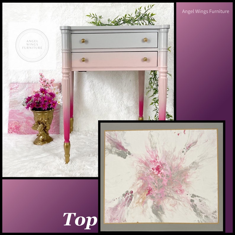 May include: A two-drawer side table with a gray and pink ombre paint finish. The table has gold hardware and gold painted legs. The top of the table is painted with a pink and gray abstract design.