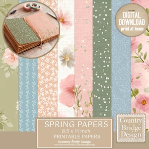 Op de afbeelding: Een verzameling lente-thema printbare papieren in verschillende pastelkleuren, waaronder roze, groen en blauw, met bloemen- en stippenpatronen. De papieren zijn 21,6 x 27,9 cm. Een klein notitieboekje en washitape zijn zichtbaar. De tekst luidt "SPRING PAPERS".