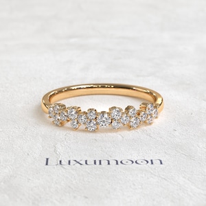 May include: A gold ring featuring a cluster of small, round, clear stones set along the front half of the band. The band has a polished finish and the stones are arranged in a dense, multi-layered formation. The text Luxumoon is printed below.