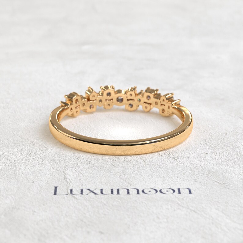 May include: A gold ring featuring a cluster of small, clear stones set along the top half of the band. The band is smooth and polished, with a rounded profile. Below the ring, the word Luxumoon is printed in a dark, sans-serif font.