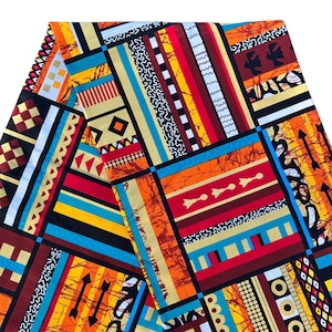 May include: A folded fabric with a vibrant, geometric pattern. The design features a patchwork of rectangles and squares in a variety of colors, including orange, red, yellow, blue, and black. The fabric has a bold, tribal-inspired aesthetic.